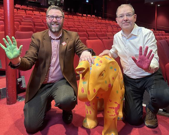 Two men and an small elephant sculture