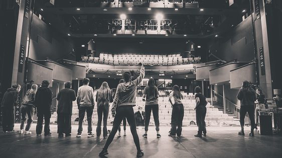 Photo of some of the young garrick cast during a rehearsal on the main stage taken from behind the cast looking out into the main auditorium