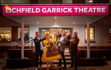 Four men outside the theatre
