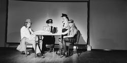Four young actors on stage in a play