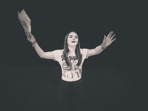Young woman on stage with her arms in the air