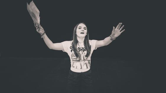 Young woman on stage with her arms in the air